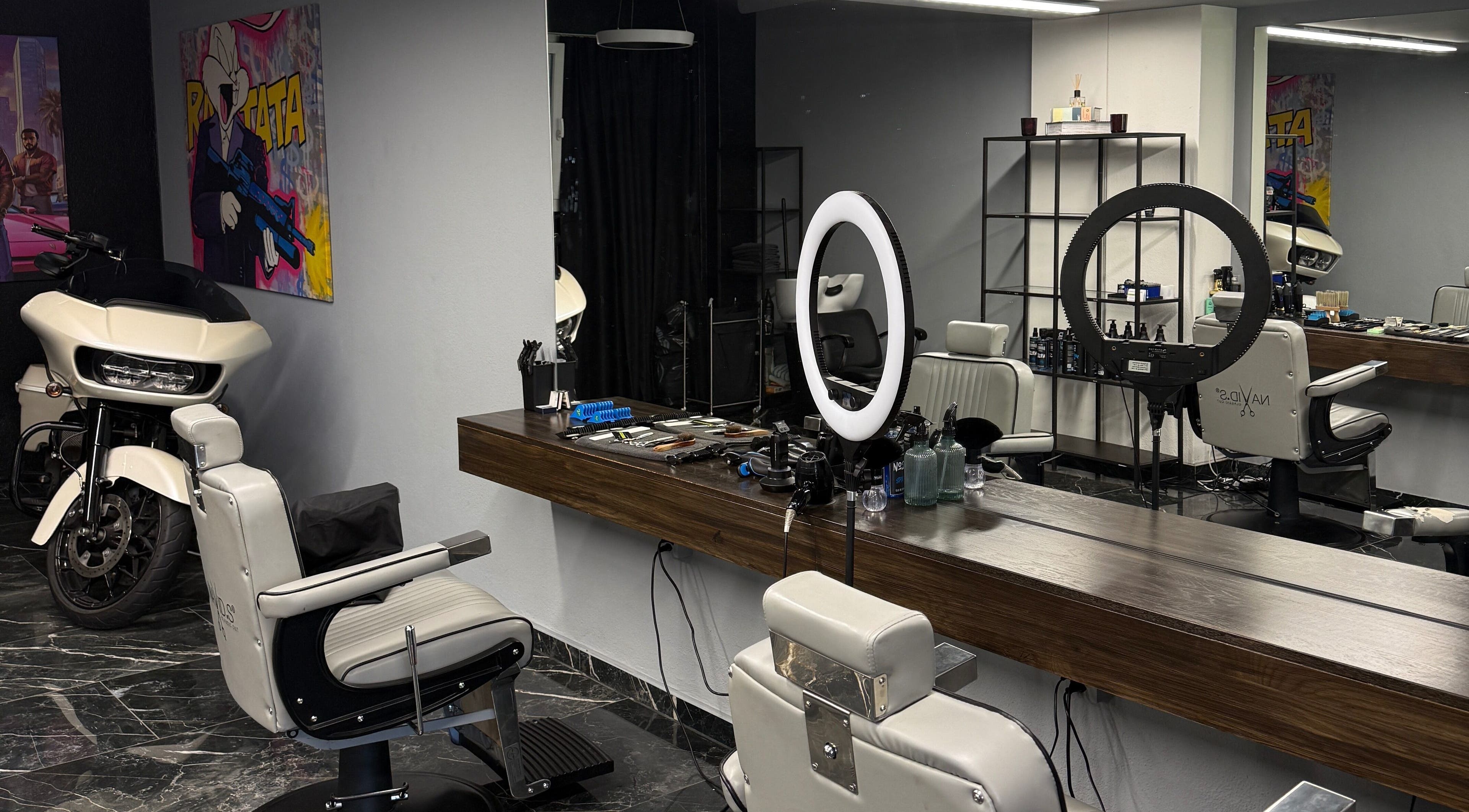 Modern barbershop interior at mmpcutz, Uster, Zürich, CH with white chairs and sleek design.