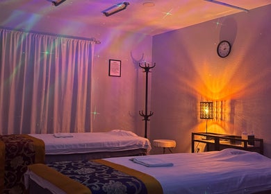 Tranquil massage room at A Magic Massage INC, Winter Park, Florida, US with cozy lighting and two massage tables.