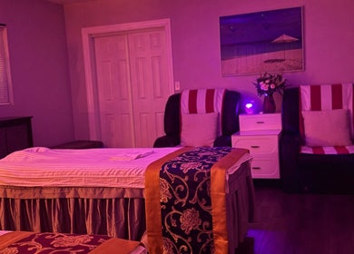 Relaxing massage room at A Magic Massage INC in Winter Park, Florida, US, featuring soothing purple lighting.