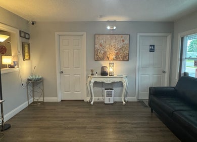 Cozy reception area at A Magic Massage INC in Winter Park, Florida, US, with elegant decor and a black sofa.