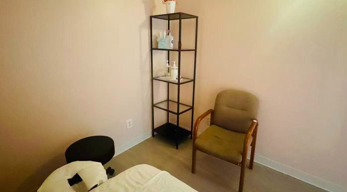 Cozy massage room at Massage Pro, Virginia, featuring a plush chair and organized shelf.