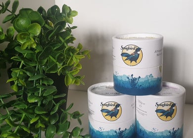 Songbird massage balms at Knotts Massage, Nottingham, England, GB, alongside lush green plants.