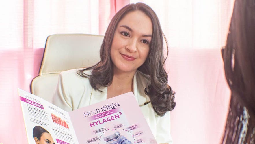 Consultant at Velvet Skin, La Libertad, SV, reviewing skincare brochure with client.