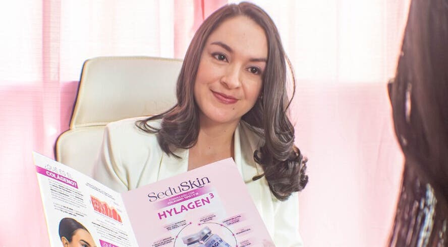 Consultant at Velvet Skin, La Libertad, SV, reviewing skincare brochure with client.