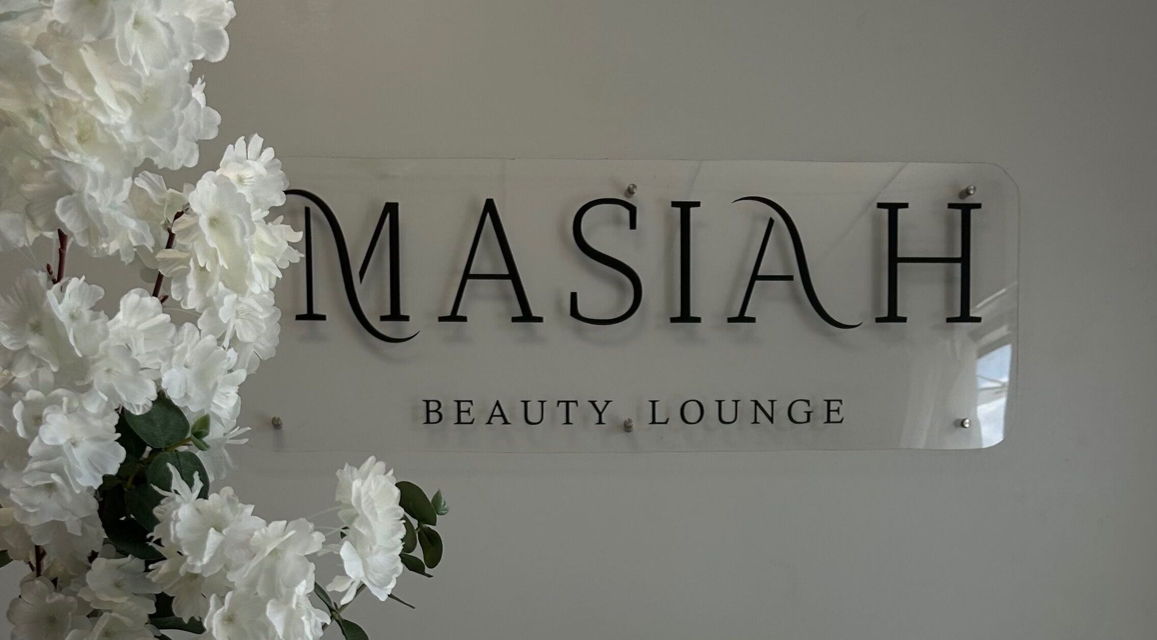 Masiah Beauty Lounge elegant signage in Paramaribo, Paramaribo, SR with white floral decor.