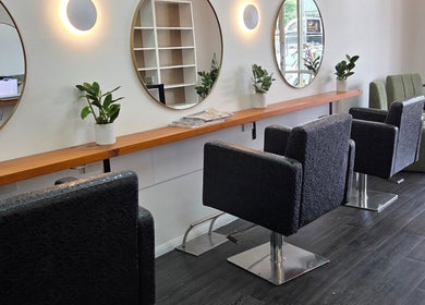 Modern interior of Papillon salon in Hendra, Queensland, AU, featuring sleek styling stations and round mirrors.