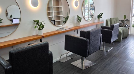 Modern interior of Papillon salon in Hendra, Queensland, AU, featuring sleek styling stations and round mirrors.
