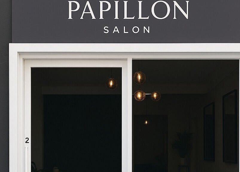 Front entrance of Papillon salon in Hendra, Queensland, AU with elegant black and white signage.