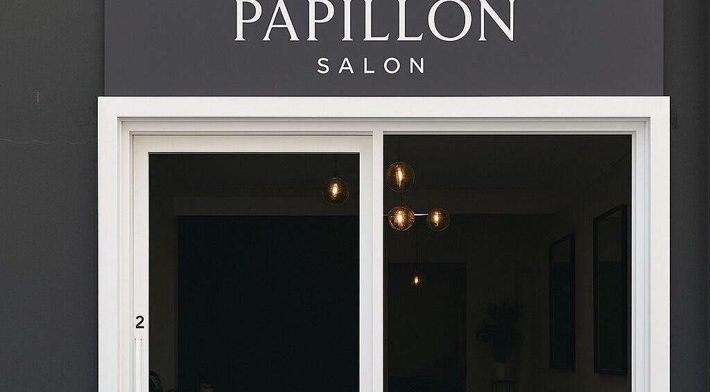 Front entrance of Papillon salon in Hendra, Queensland, AU with elegant black and white signage.