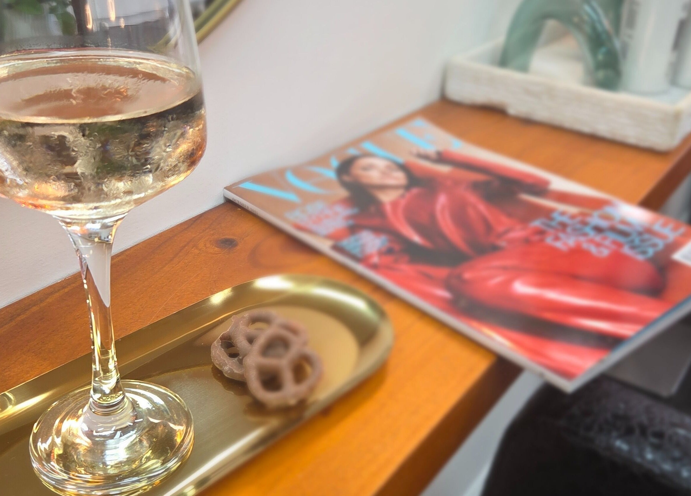 Glass of wine and magazine at Papillon salon, Hendra, Queensland, AU, embodying a stylish ambiance.
