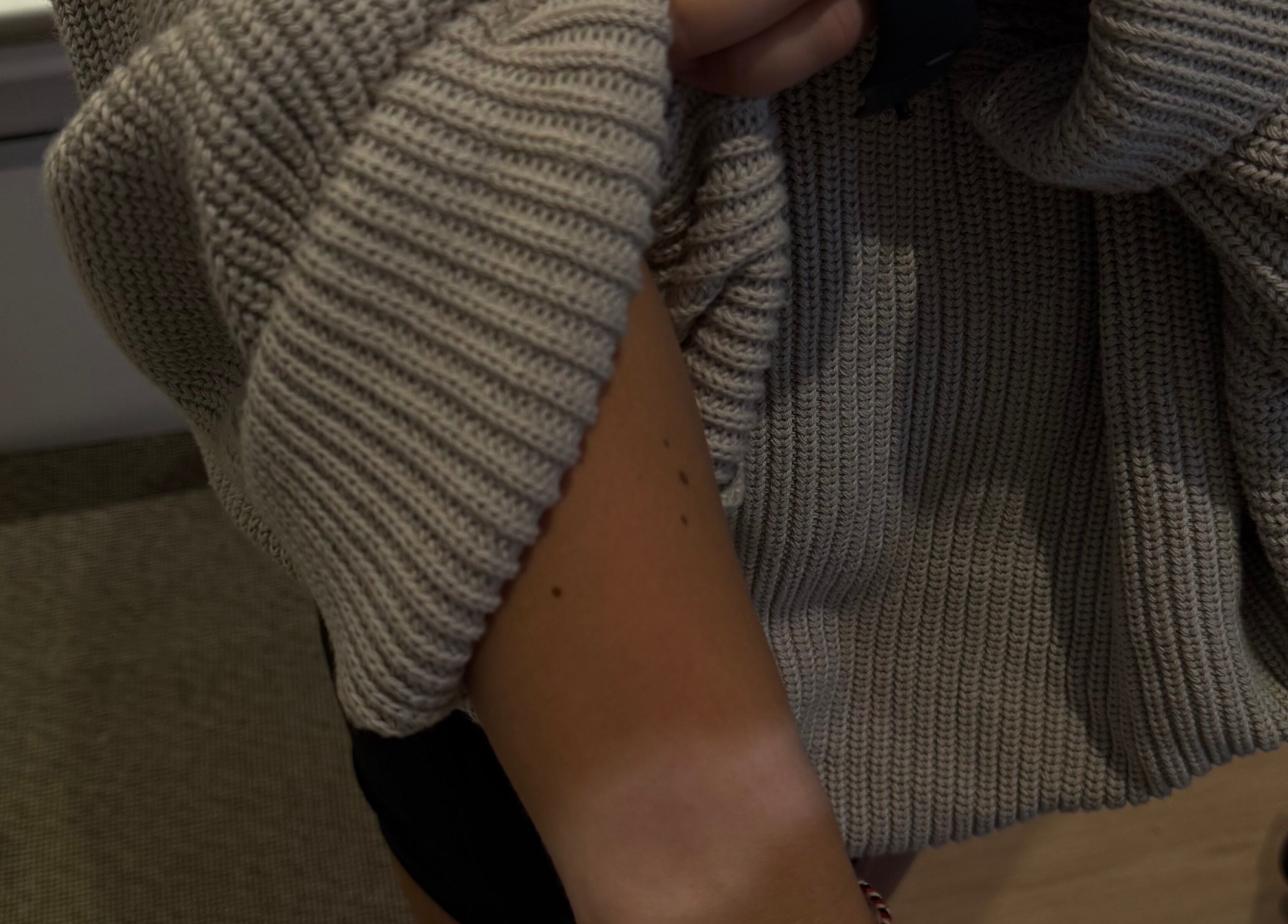 Close-up of a cozy sweater sleeve on a tanned arm at Makeme.TAN, Lightsview, South Australia, AU.