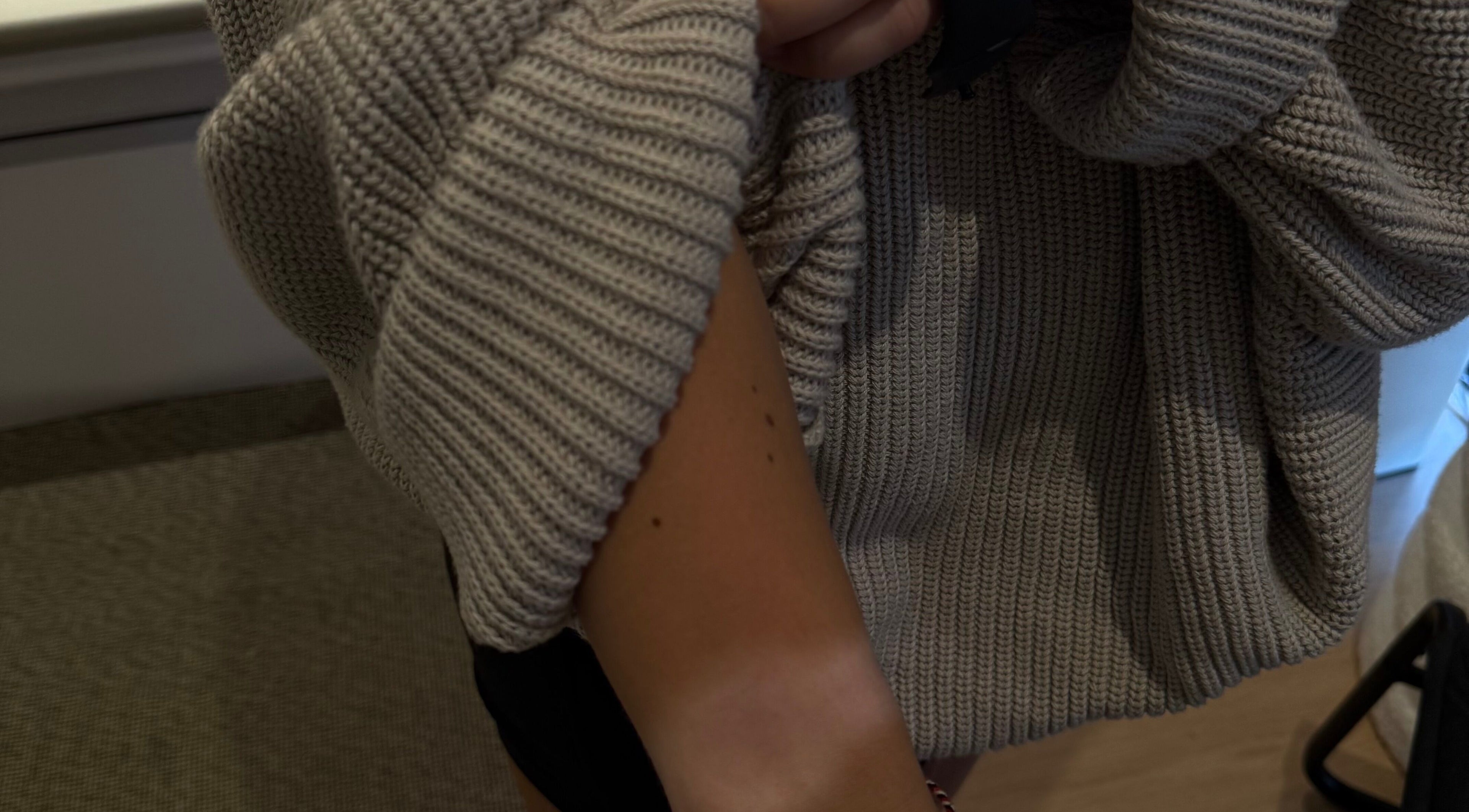 Close-up of a cozy sweater sleeve on a tanned arm at Makeme.TAN, Lightsview, South Australia, AU.
