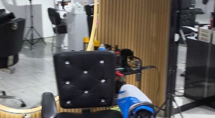 Silla de barbería en Majestic Barberia Y Peluqueria, Bogotá, Cundinamarca, CO, con espejo moderno y decoraciones.
