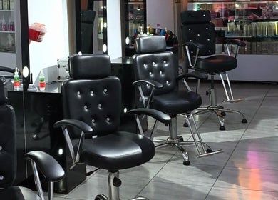 Interior moderno de London Barberia Y Peluqueria en Bogotá, Cundinamarca, CO, mostrando sillas de diseño negro.