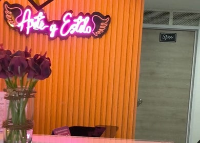Recepción iluminada de London Barberia Y Peluqueria en Bogotá, Cundinamarca, CO con flores y letrero LED.