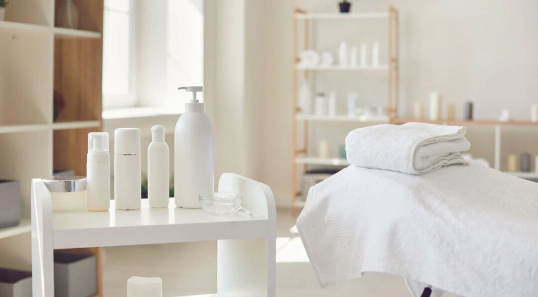 Spa treatment room at New Era Brows & Beauty, Chiswick, New South Wales, AU. White towels and skincare products.