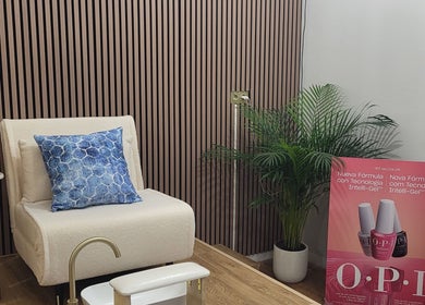 Espacio acogedor en Shanakay Nails, San Sebastián De Los Reyes, con silla beige y cojín azul.