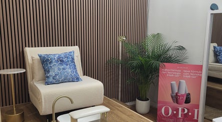 Espacio acogedor en Shanakay Nails, San Sebastián De Los Reyes, con silla beige y cojín azul.