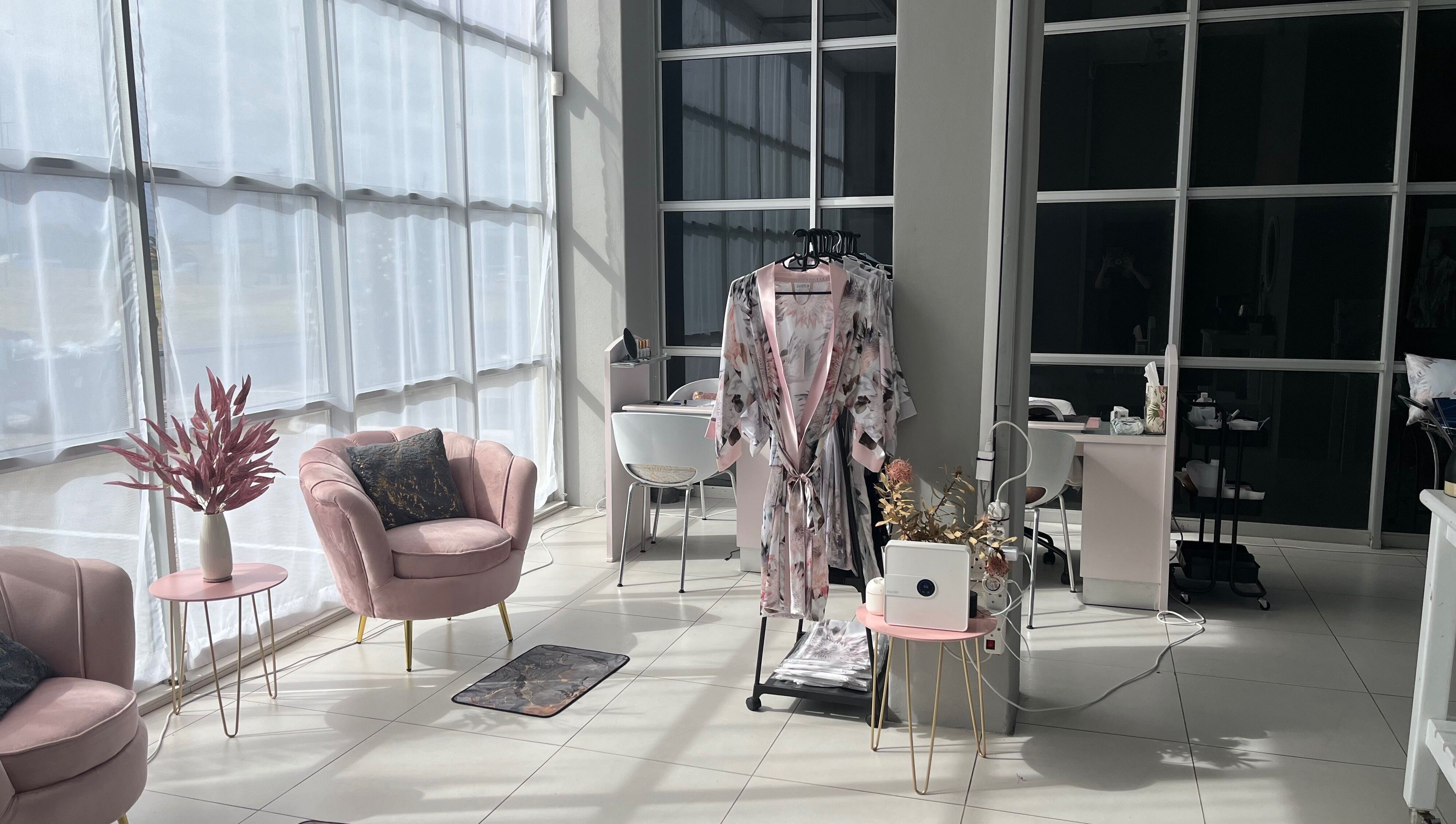 Modern lounge area at Bev's Beauty and Wellness Somerset West, Cape Town, Western Cape, ZA with plush pink chairs.