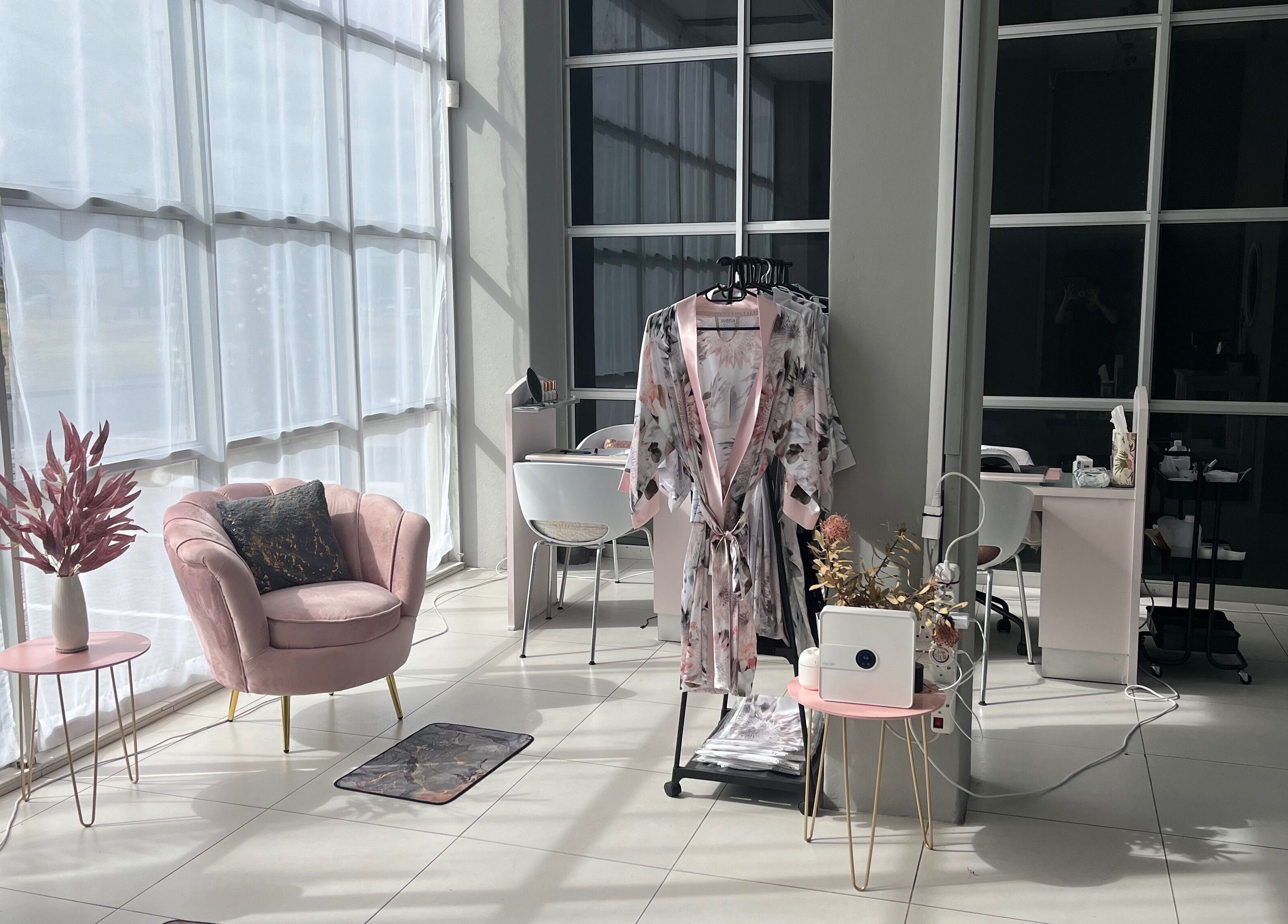 Modern lounge area at Bev's Beauty and Wellness Somerset West, Cape Town, Western Cape, ZA with plush pink chairs.