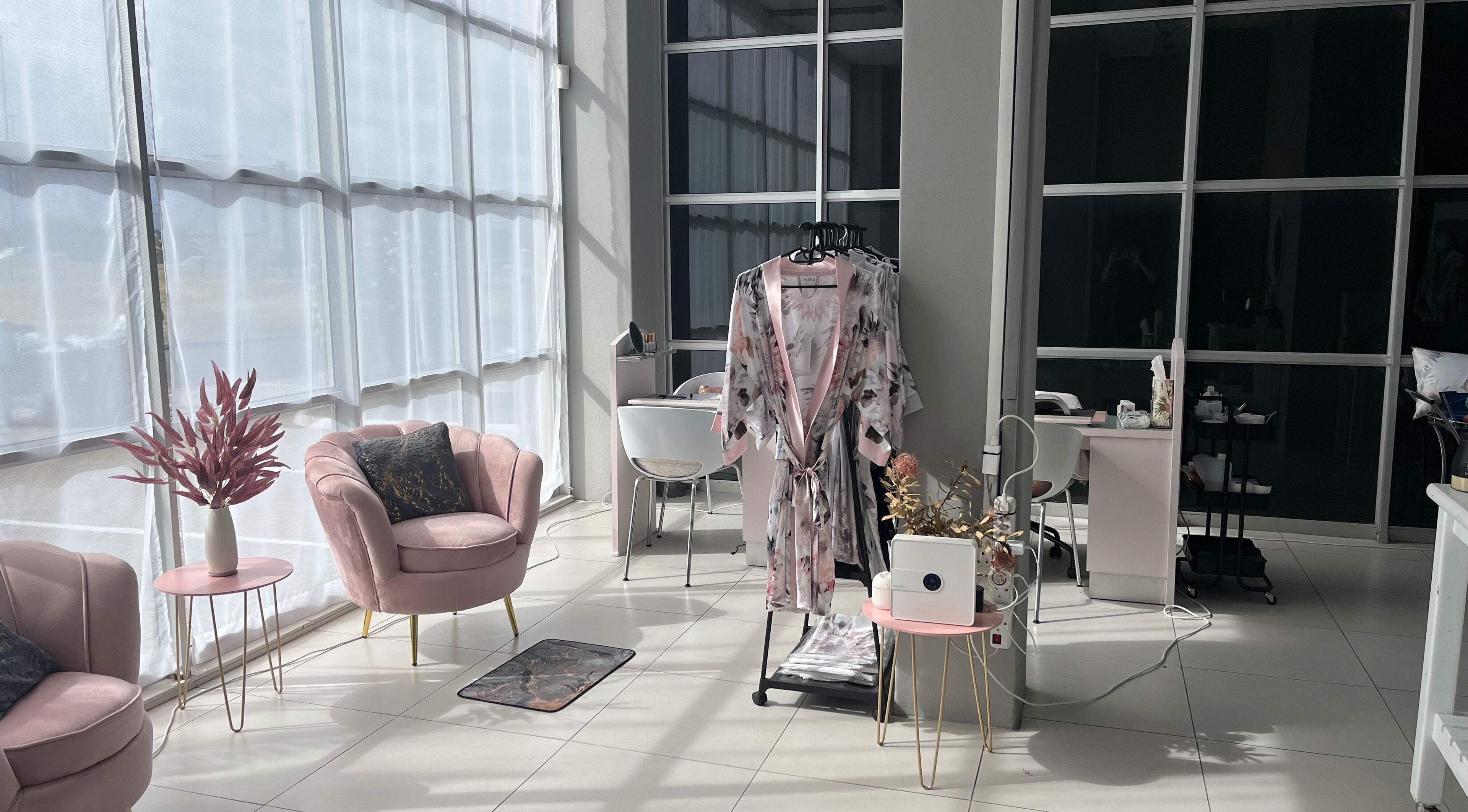 Modern lounge area at Bev's Beauty and Wellness Somerset West, Cape Town, Western Cape, ZA with plush pink chairs.