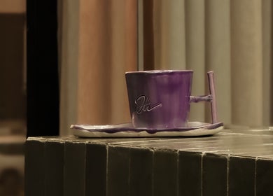 Purple ceramic cup at Double H Salon & Spa, Hail, Hail Province, SA, offering a relaxing ambiance.