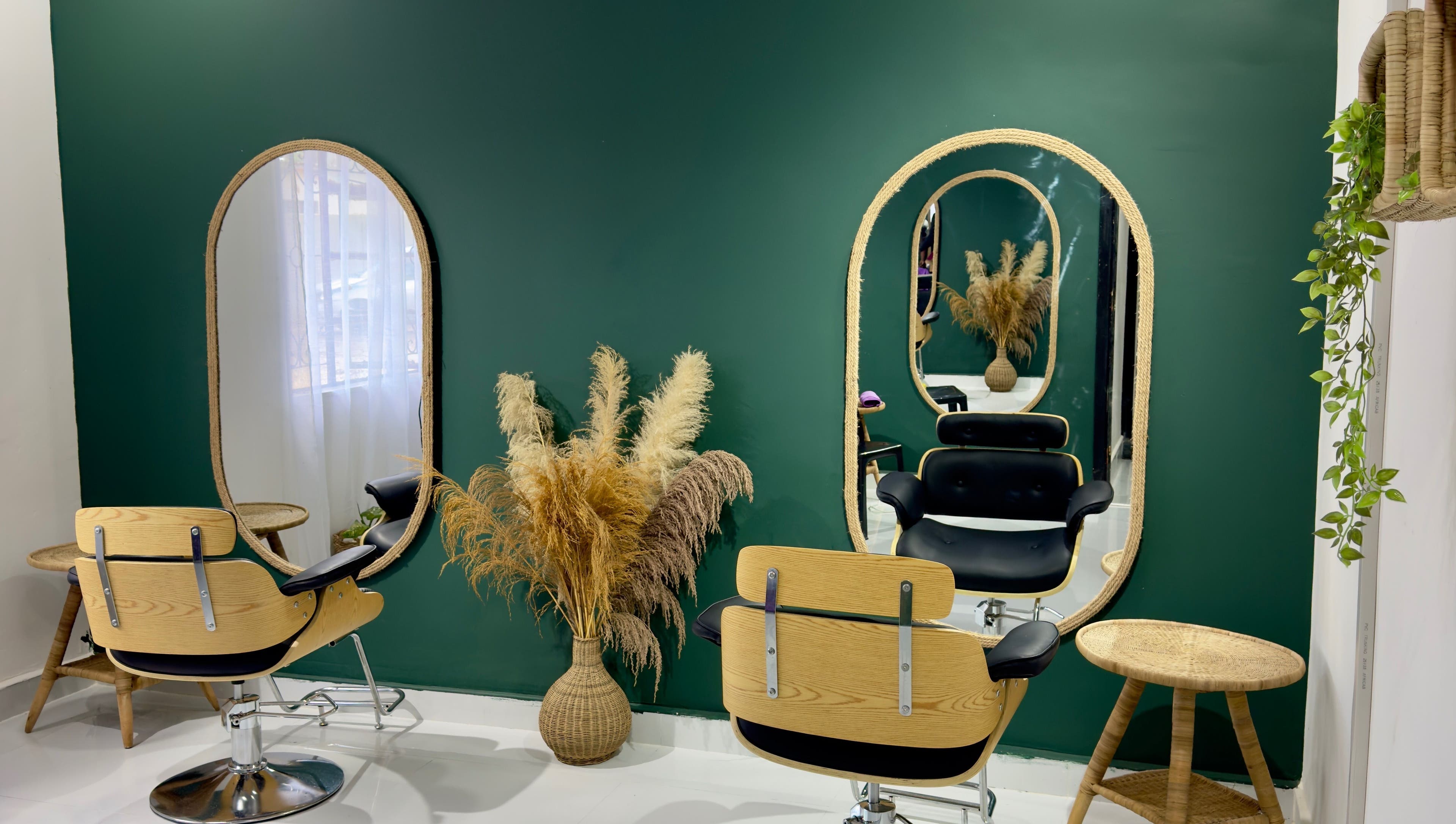 Stylish salon setup at Bloom by Her Rootz - Woodlands in Lusaka, Lusaka Province, ZM with mirrors and green walls.