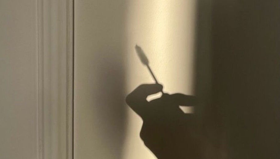 Silhouette of a hand holding a makeup brush at Bloom_hays_beauty, Nottingham, England, GB.