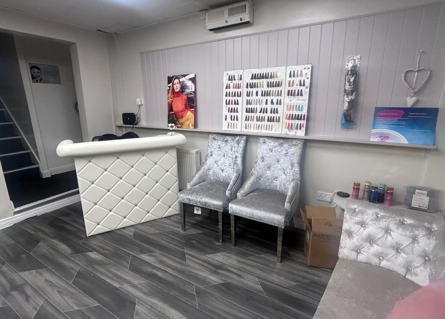 Elegant interior of B’Glammed By Us in Leyland, England, GB showcasing nail color displays and plush seating.