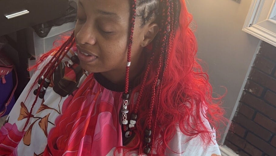 Colorful braids styled at Hair & Skin By Amber in Conyers, Georgia, US, showcasing vibrant red hues.