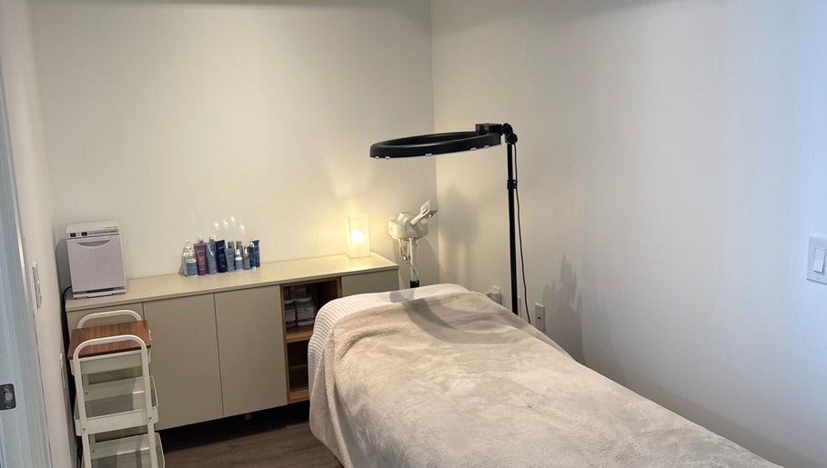 SkinByBrooke treatment room in Toronto, Ontario, CA with cozy massage bed and well-organized skincare products.