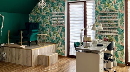 Przytulne wnętrze w Coś Pięknego Studio Urody, Gronków, Województwo Małopolskie, PL z kolorową tapetą i eleganckim fotelem.