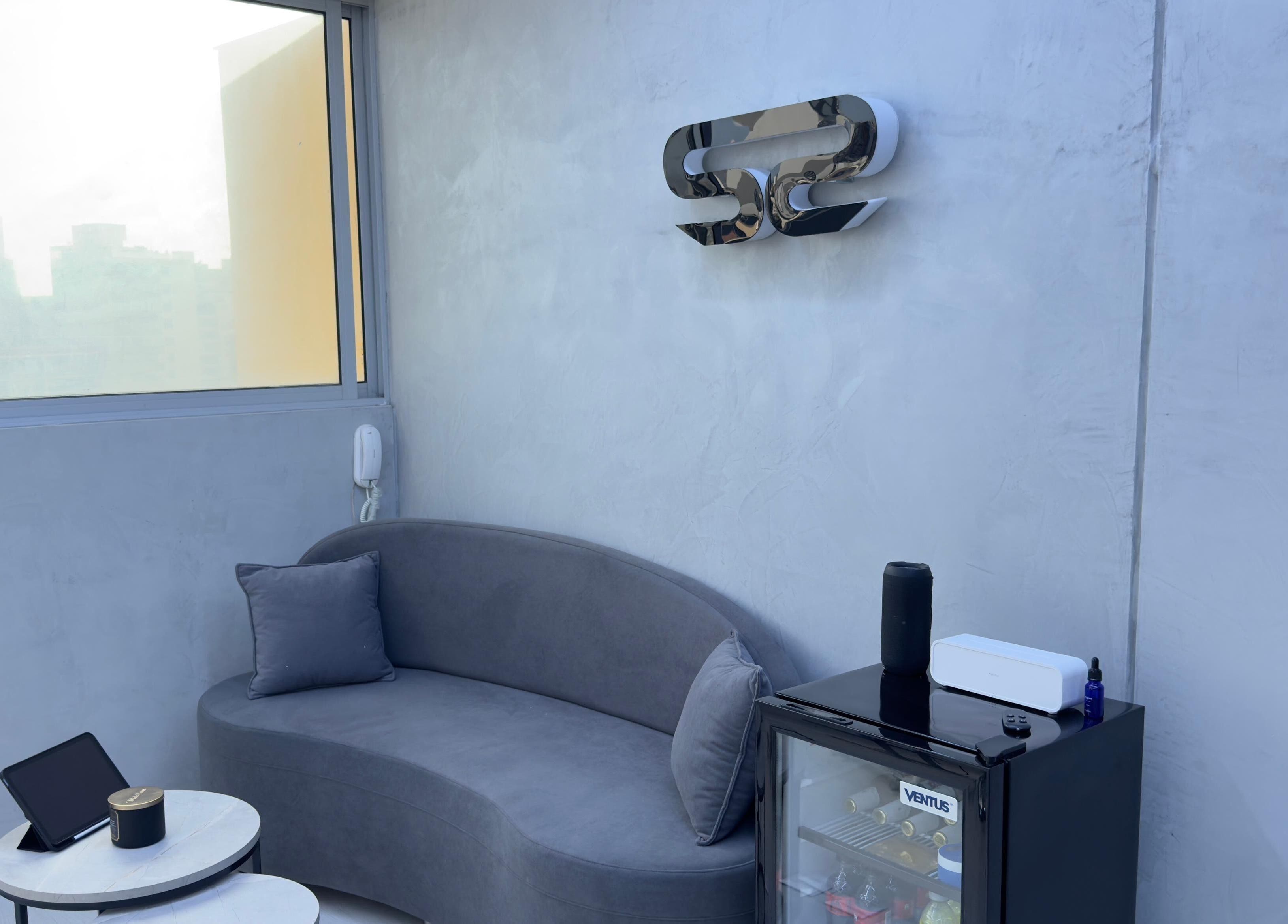 Área de descanso moderna en Sharp Studio, Magdalena Del Mar, Provincia De Lima, PE con sofá gris y minibar.