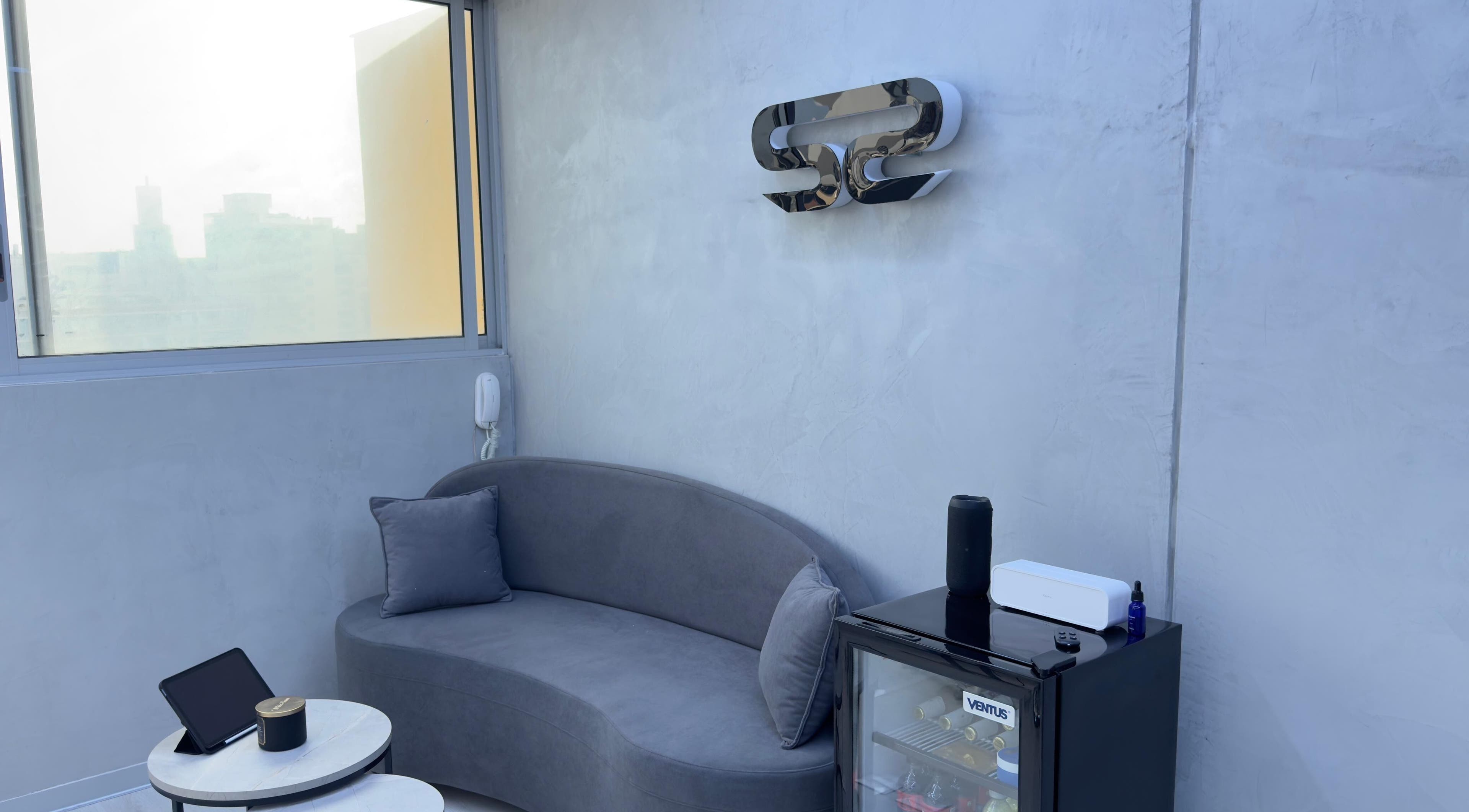 Área de descanso moderna en Sharp Studio, Magdalena Del Mar, Provincia De Lima, PE con sofá gris y minibar.