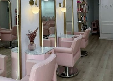 Chic interior of Qasar Al Yasmeen Ladies Saloon in Sharjah, Sharjah, AE with pink chairs and stylish mirrors.