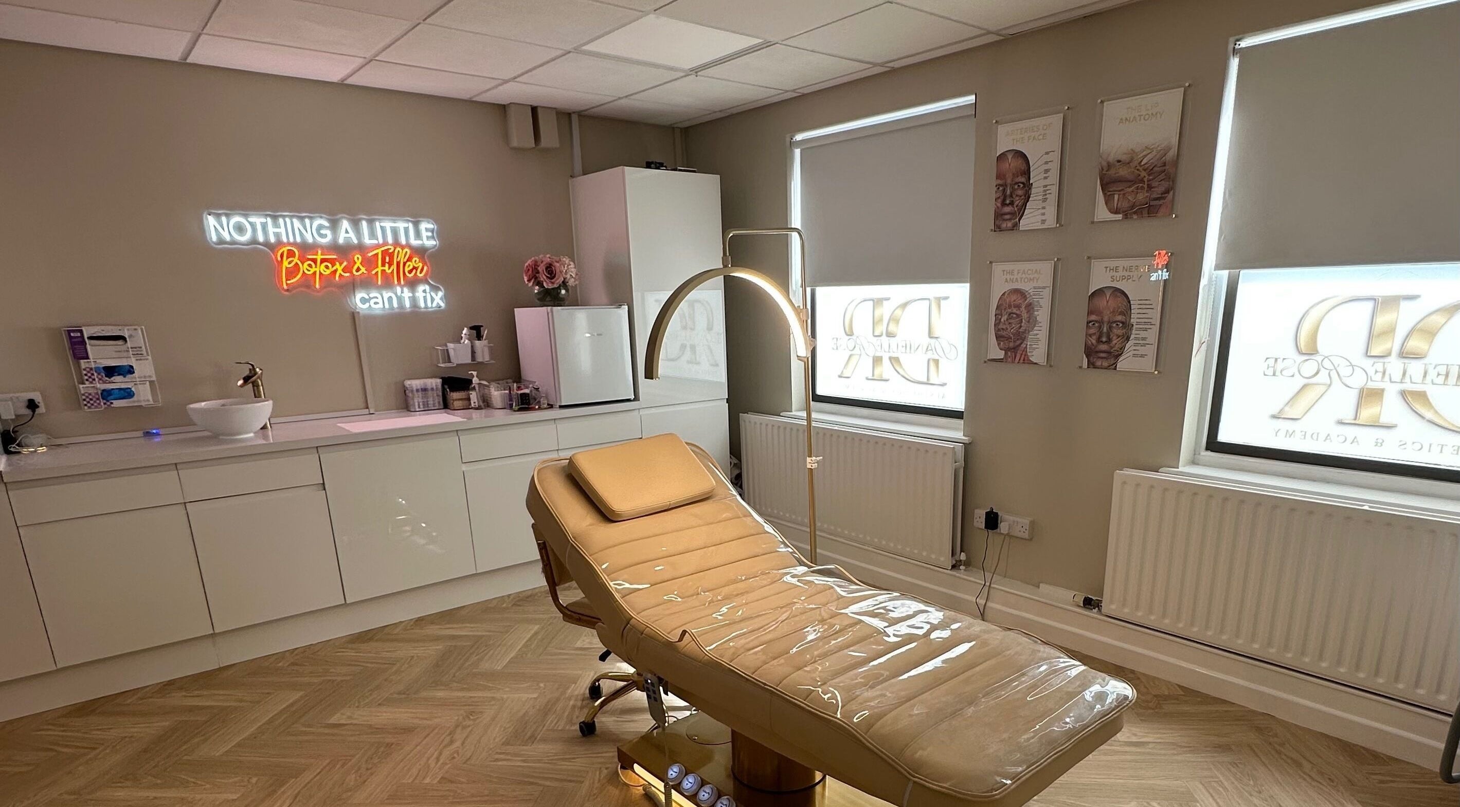 Modern treatment room at Danielle Rose Aesthetics, Southampton, England, GB with a sleek chair and neon sign.