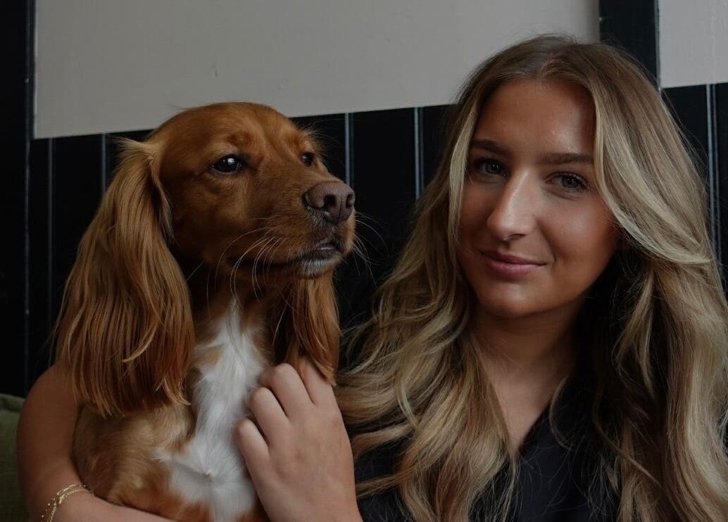Woman with a dog at Teddy’s Tailored Trims, Penrith, England, GB, enjoying a warm atmosphere.