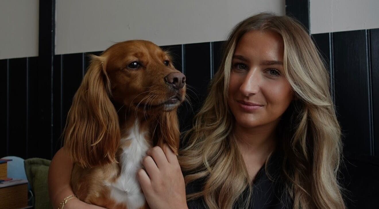 Woman with a dog at Teddy’s Tailored Trims, Penrith, England, GB, enjoying a warm atmosphere.