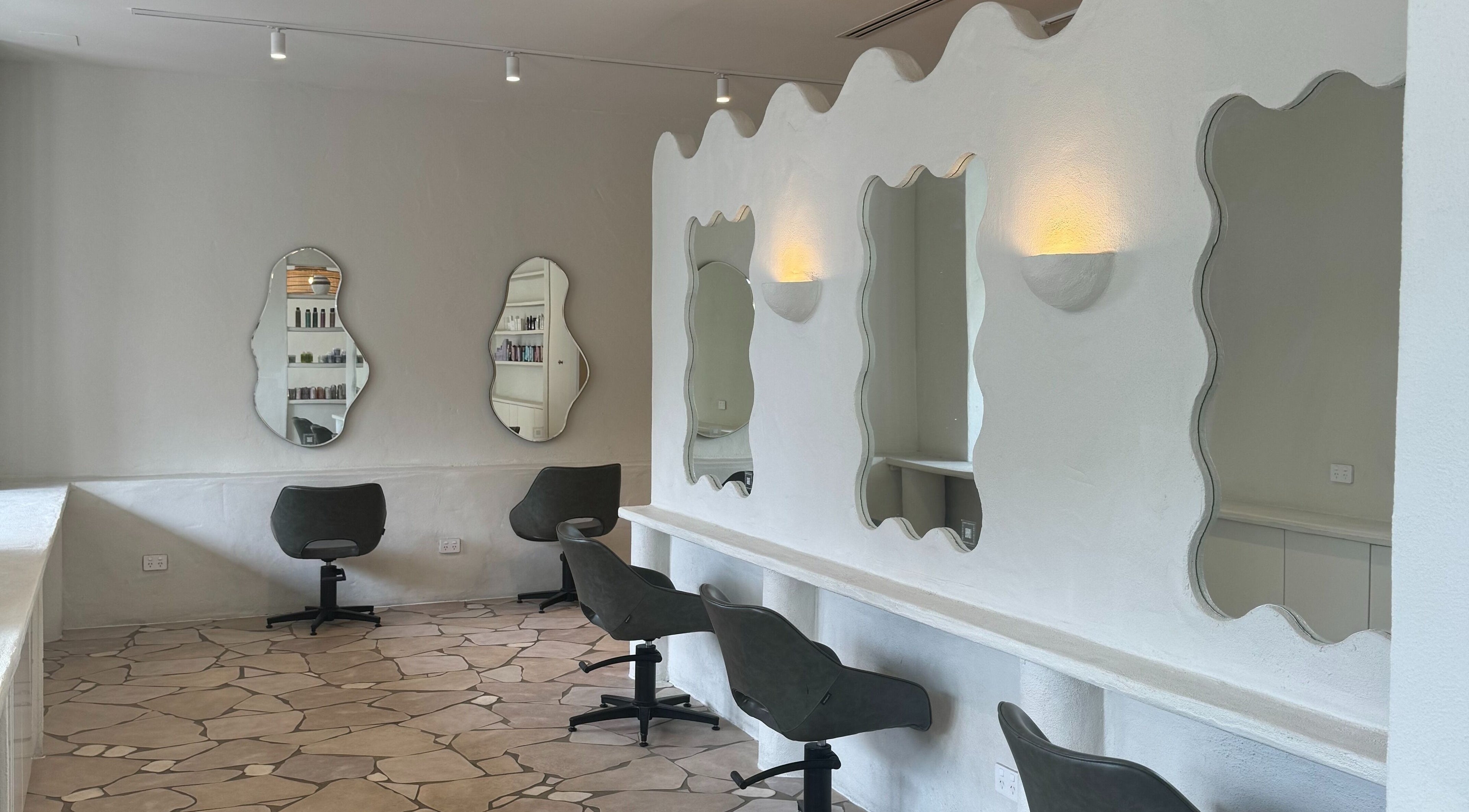 Modern salon interior at Farrah Studio in New Farm, Queensland, AU with stylish mirrors and chairs.