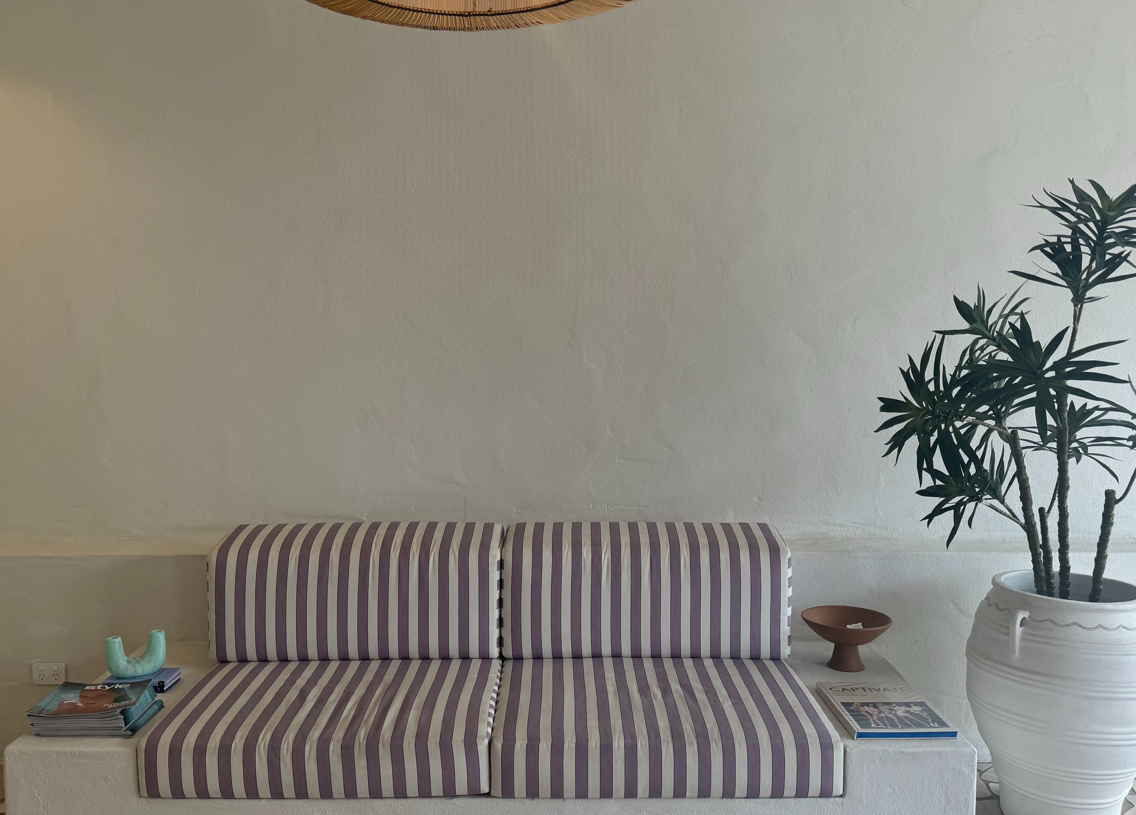 Striped couch and potted plant at Farrah Studio, New Farm, Queensland, AU creating a serene ambiance.