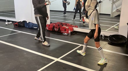 Fencing lesson at Fence MI Fencing Academy in Las Vegas, Nevada, US with mirrored practice area.