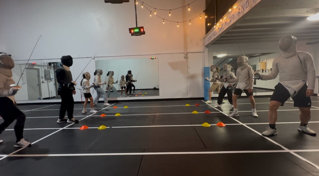 Fencers in action at Fence MI Fencing Academy, Las Vegas, Nevada, US, practicing on dueling strips.