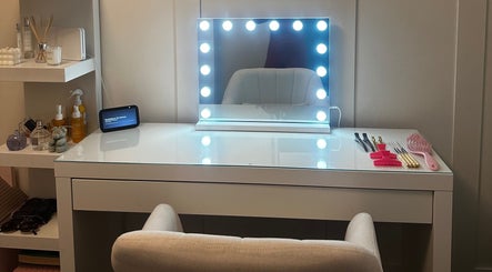 Luxelocksbyizz in Brentwood, England, GB features a chic vanity with illuminated mirror and beauty tools.