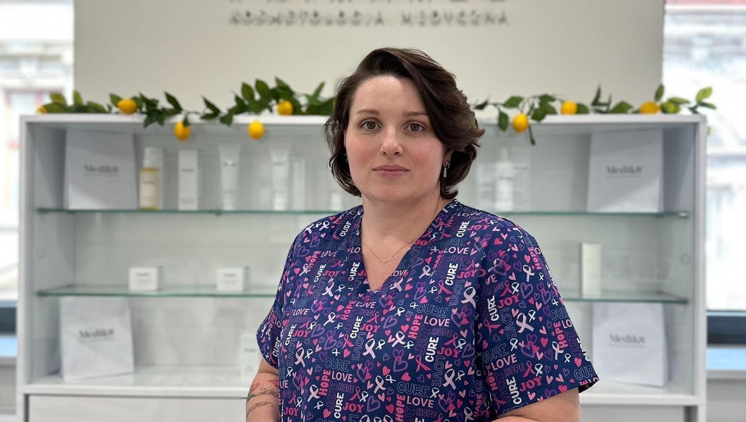 Specjalistka w Terapia dotykowa, Bielsko-Biała, Województwo Śląskie, PL, przed gablotką z kosmetykami.