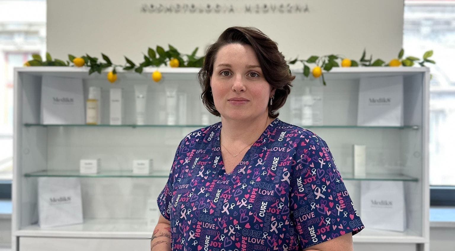 Specjalistka w Terapia dotykowa, Bielsko-Biała, Województwo Śląskie, PL, przed gablotką z kosmetykami.