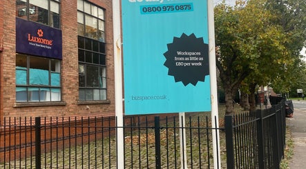 Brick building exterior near MassaAge, Manchester, England, GB with workspace signage.