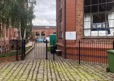 Entrance to MassaAge, a charming red brick building in Manchester, England, GB with a gated fence.