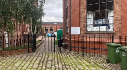 Entrance to MassaAge, a charming red brick building in Manchester, England, GB with a gated fence.