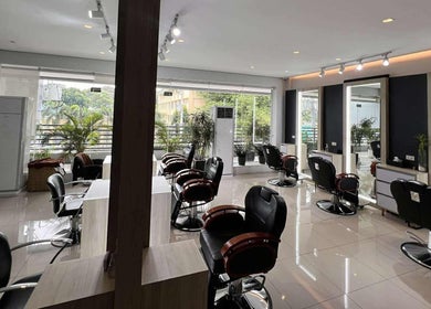 Spacious interior of Behind The Chair by Reymark Castro Salon in Quezon City, Metro Manila, PH, featuring modern chairs.