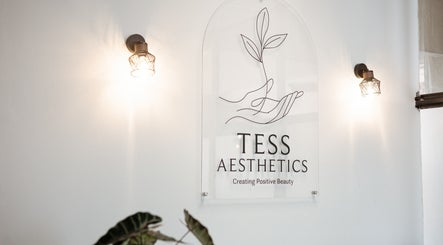 Tess Aesthetics sign adorned on a white wall in Johannesburg, Gauteng, ZA, elegantly lit by wall lamps.